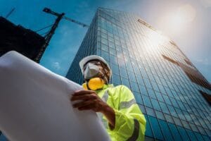 construction worker below skyscraper