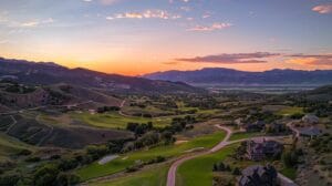 a panoramic view of a pristine utah landscape, showcasing expansive rolling hills and rugged mountains under a vibrant sunset, emphasizing the vastness and beauty of property survey solutions in the region.