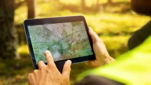 A surveyor working with forest topographic survey map on a digital tablet.