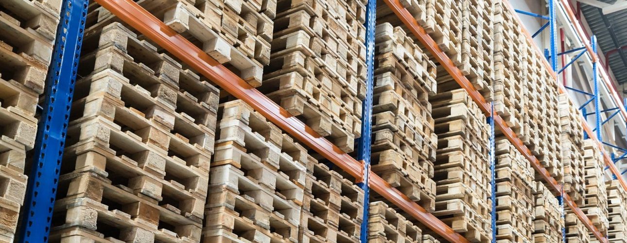 Huge distribution warehouse with wooden pallets on high shelves