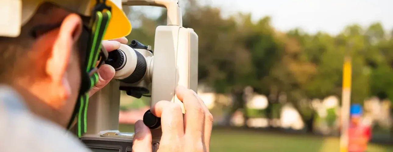 AdobeStock_47949602 copy Surveyor engineer with partner making measure on the field