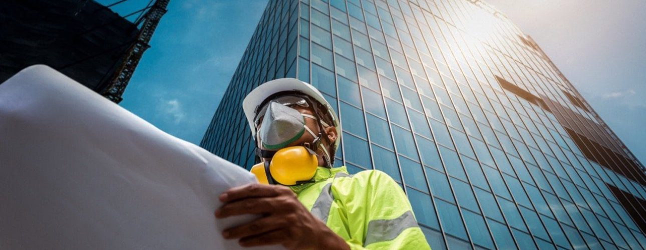 construction worker below skyscraper