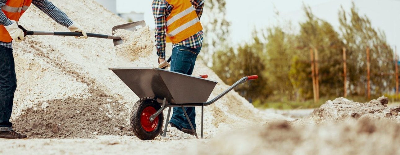 Low angle on teamwork of construction workers in orange safety v